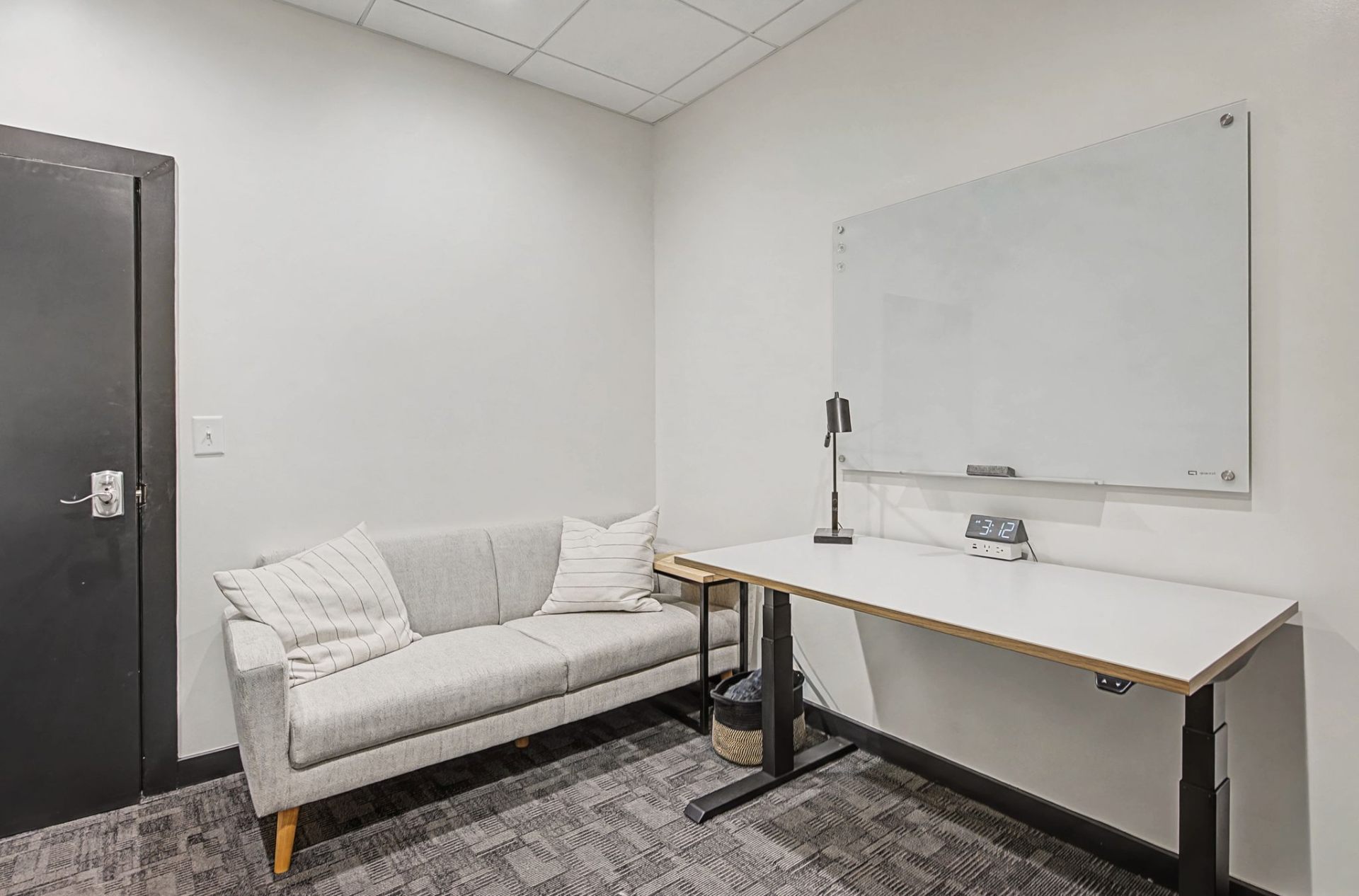 Private office with sofa, standing desk and whiteboard